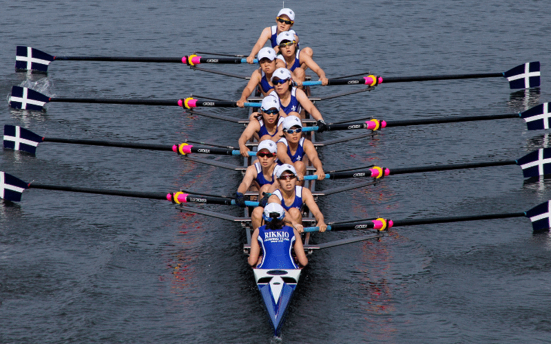 A group of young rowers follow a structured training plan on the water, guided by a coach. They execute various exercises and drills with determination and teamwork