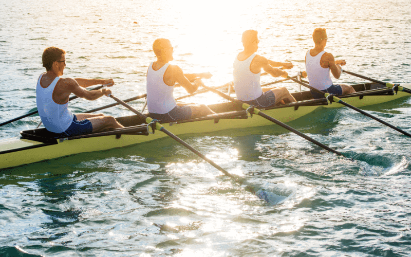 The team's oars slicing through the water, creating ripples as the eight-person rowing boat glides across the smooth surface of the river